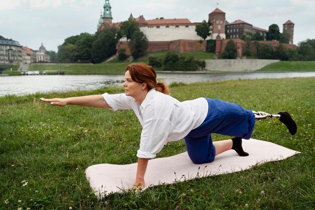 Mujer con prótesis de pierna haciendo yoga