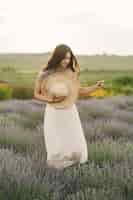 Foto gratuita mujer provenzal relajante en campo de lavanda. dama con sombrero de paja.