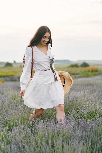 Mujer provenzal relajante en campo de lavanda. dama con un vestido blanco.