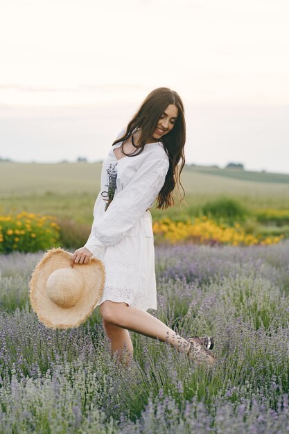 Mujer provenzal relajante en campo de lavanda. Dama con un vestido blanco.