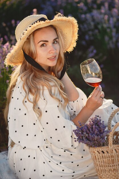 Mujer provenzal relajante en campo de lavanda. Señora en un picnic. Mujer con sombrero de paja.