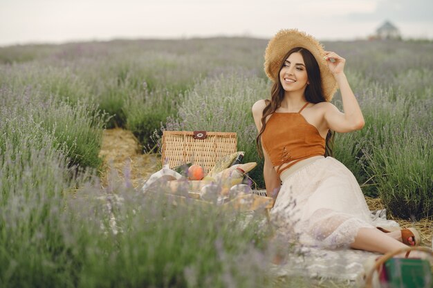 Mujer provenzal relajante en campo de lavanda. Señora en un picnic.