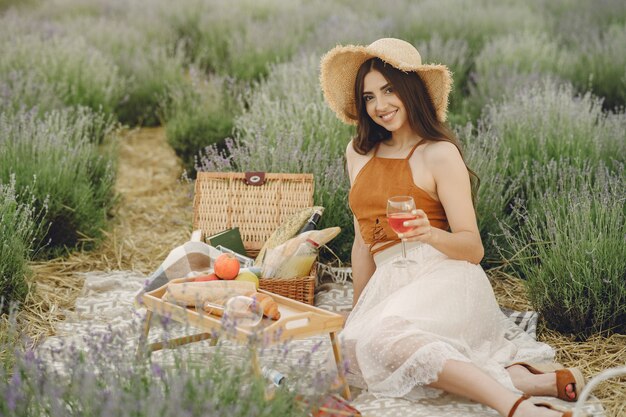 Foto gratuita mujer provenzal relajante en campo de lavanda. señora en un picnic.