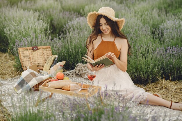 Mujer provenzal relajante en campo de lavanda. Señora en un picnic.