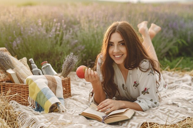 Mujer provenzal relajante en campo de lavanda. Señora en un picnic.