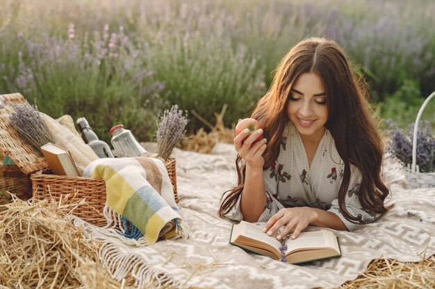 Mujer provenzal relajante en campo de lavanda. Señora en un picnic.