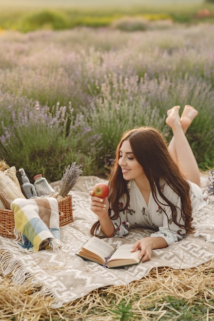 Mujer provenzal relajante en campo de lavanda. Señora en un picnic.