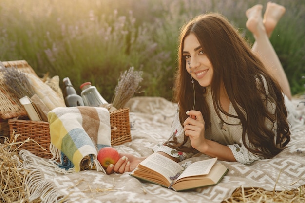 Mujer provenzal relajante en campo de lavanda. Señora en un picnic.