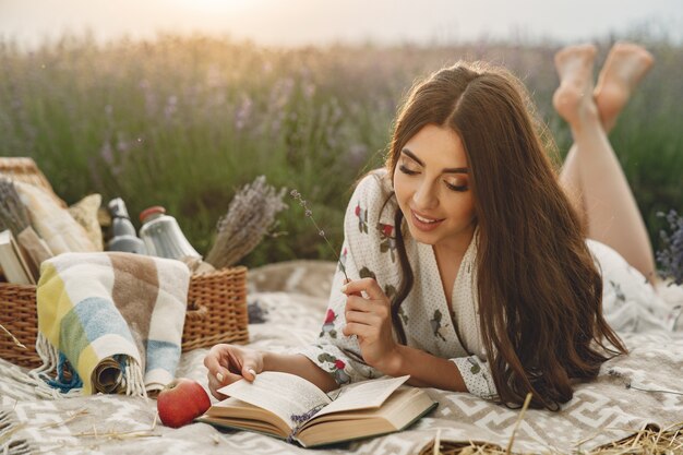 Mujer provenzal relajante en campo de lavanda. Señora en un picnic.