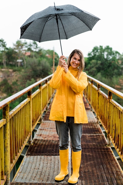 Mujer en puente sosteniendo un paraguas