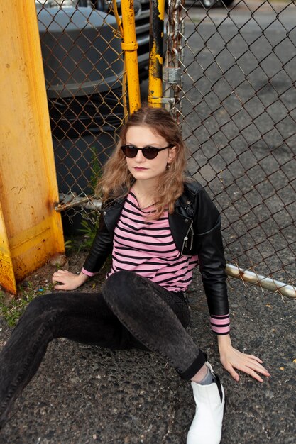 Mujer punk con gafas de sol en ubicación urbana