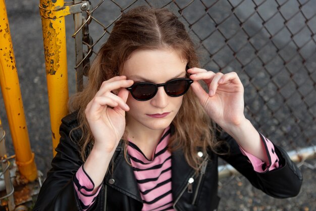 Mujer punk con gafas de sol en ubicación urbana