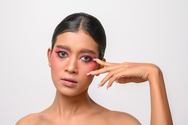 Mujer se puso maquillaje rosa y puso su mano sobre su rostro aislado en blanco