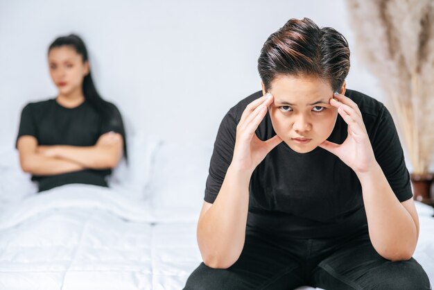 Una mujer que se ama se enoja y se sienta en la cama.