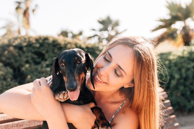 Mujer que ama a su perro lindo que saca la lengua