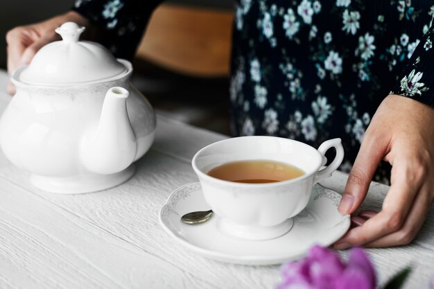 Mujer que se ayuda con una taza de té caliente agradable