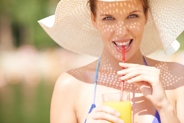 Mujer que bebe un jugo en verano