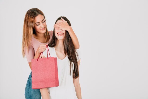 Mujer que cierra los ojos a la novia para regalar bolsa de papel