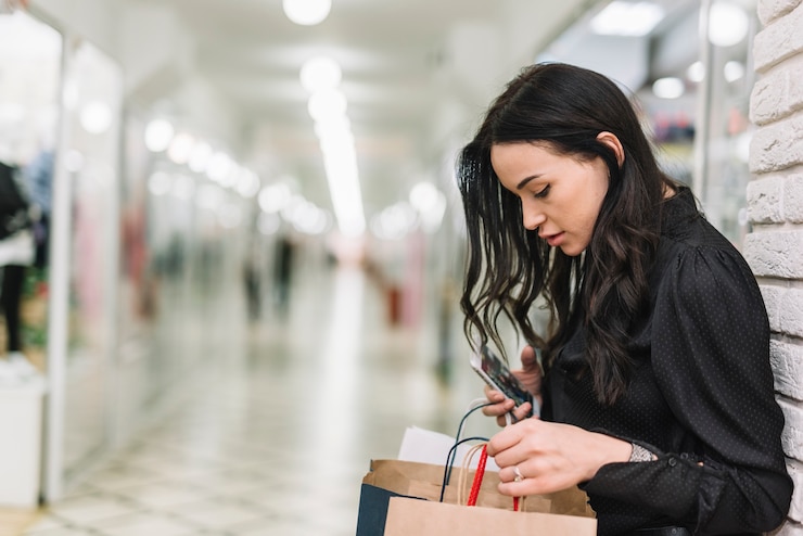 Foto gratuito mujer que controla bolsos de compras en tienda