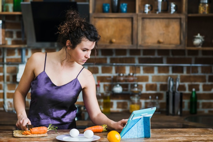 Foto gratuito mujer que controla la receta de la ensalada