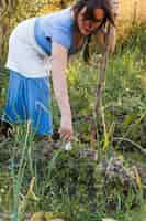 Foto gratuita mujer que cosecha la cebolla fresca del resorte en el campo