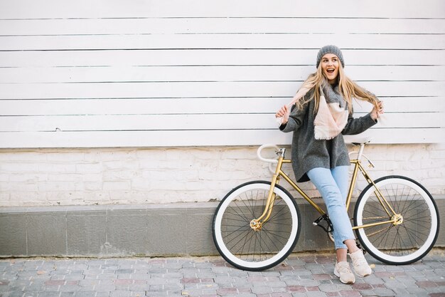 Mujer que se divierte cerca de la bicicleta