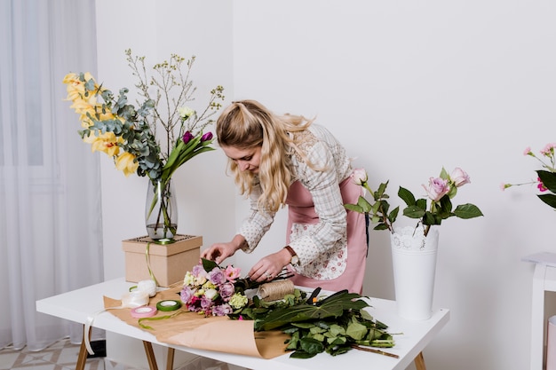 Foto gratuita mujer que envuelve el ramo de flores