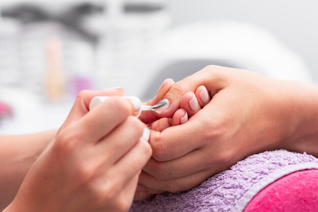 Mujer que se hace la manicura de cerca en el salón