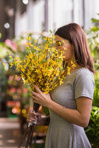 Mujer que huele flores amarillas