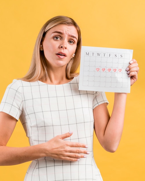 Foto gratuita mujer que imita los calambres estomacales de la menstruación