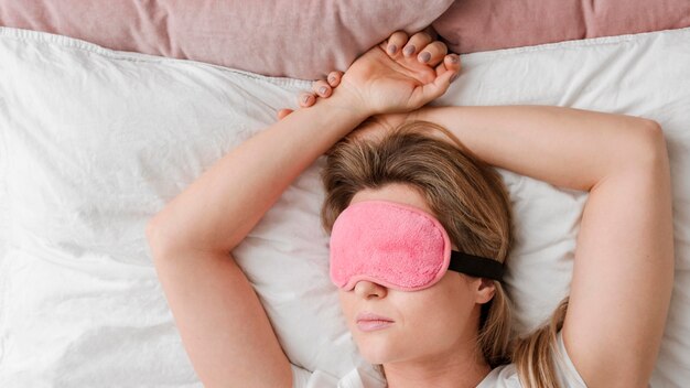 Mujer que llevaba una máscara para dormir en los ojos