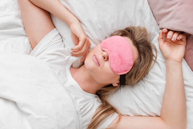 Mujer que llevaba una máscara para dormir en la vista superior de sus ojos