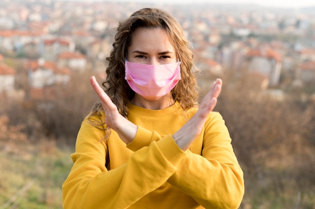 Foto gratuita mujer que llevaba una máscara médica al aire libre