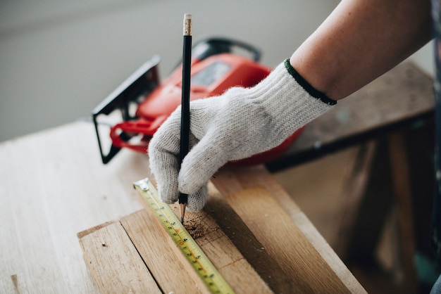 Mujer que mide un tablón de madera