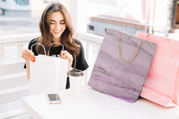 Mujer que mira compras en bolsa de papel