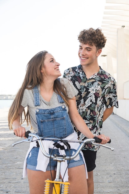 Mujer que mira a su novio mientras que monta la bicicleta