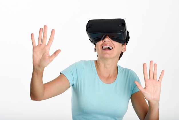 Mujer que mira en vidrios de VR y que gesticula con sus manos.