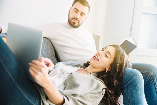 Foto gratuita mujer que muestra la computadora portátil al hombre de lectura