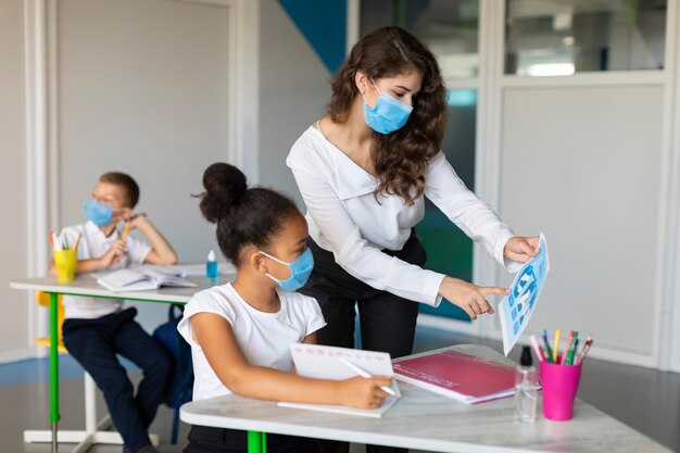 Mujer que muestra la prevención de una pandemia a un niño