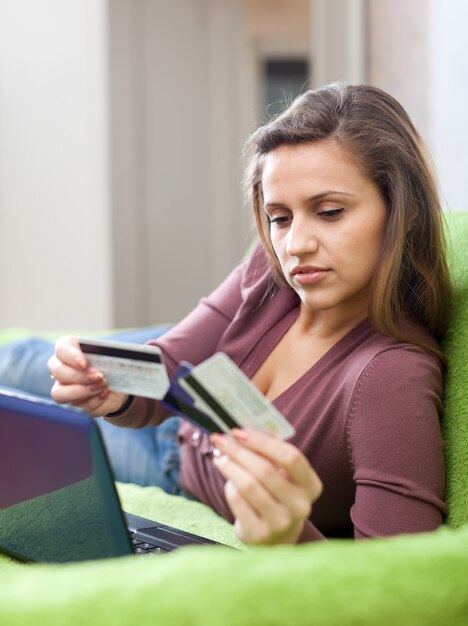 Mujer que paga con tarjeta de crédito en tienda de internet