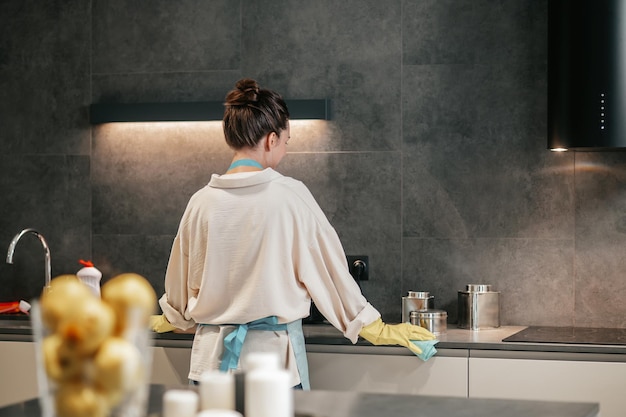 Una mujer que parece ocupada mientras limpia la cocina