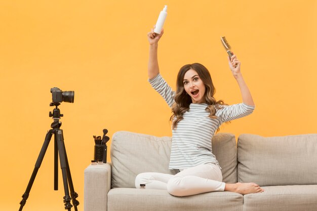 Mujer que presenta productos para el cabello en la cámara