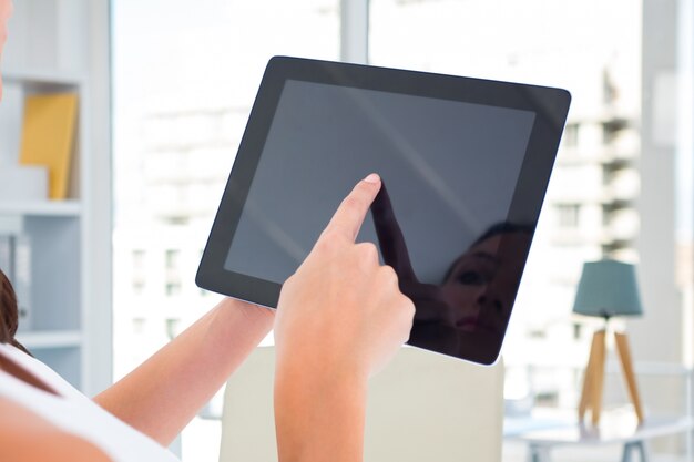 Mujer que presiona la pantalla de la tableta con un dedo