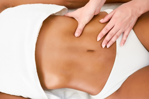 Mujer que recibe el masaje del abdomen en el centro de spa spa.