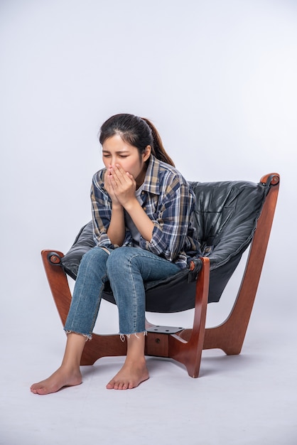 Foto gratuita una mujer que se siente incómoda y se sienta en una silla.