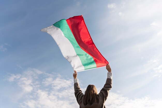 Mujer que sostiene la bandera búlgara afuera