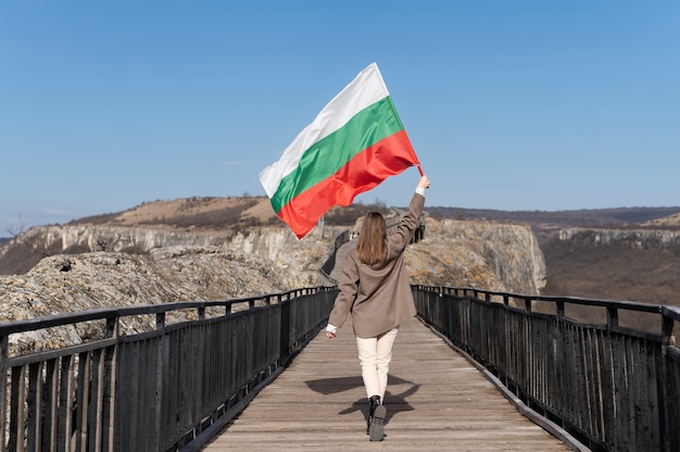 Mujer que sostiene la bandera búlgara al aire libre