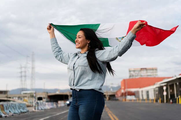 Mujer que sostiene la bandera mexicana en la calle