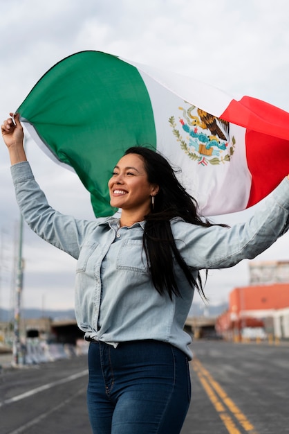 Mujer que sostiene la bandera mexicana en la calle