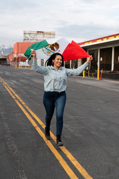 Mujer que sostiene la bandera mexicana en la calle